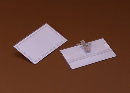 Transparente Sichthülle aus Plastik mit einem blanko, gestreiften Einsteckschild, mit Clip und Sicherheitsnagel, seitlich geöffnet - dadurch wird ein unkompliziertes Einlegen und schnelles Austauschen von Einschüben im Querformat ermöglicht.