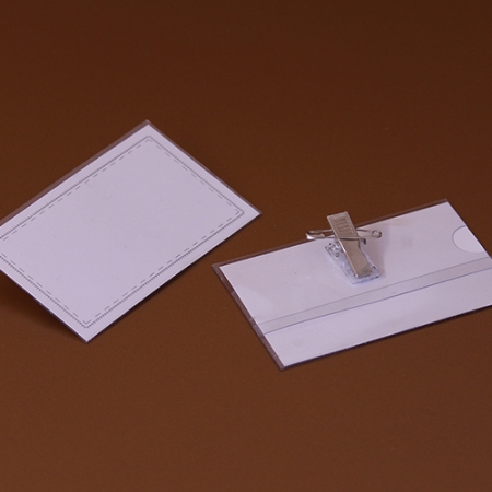 Transparente Sichthülle aus Plastik mit einem blanko, gestreiften Einsteckschild, mit Clip und Sicherheitsnagel, seitlich geöffnet - dadurch wird ein unkompliziertes Einlegen und schnelles Austauschen von Einschüben im Querformat ermöglicht.